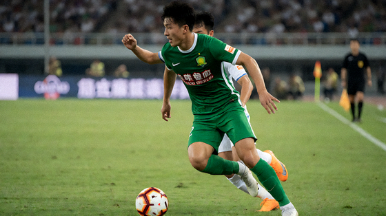 足球联赛比赛现场，球员在草坪上争抢球权